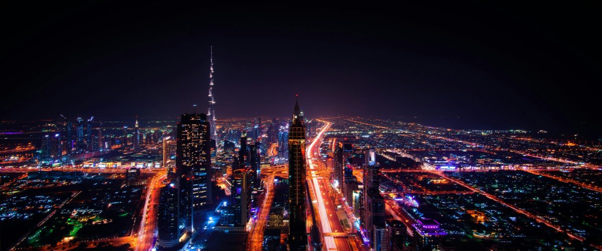 A breathtaking aerial view of Dubai's cityscape at night, highlighting the illuminated Burj Khalifa and surrounding skyscrapers.